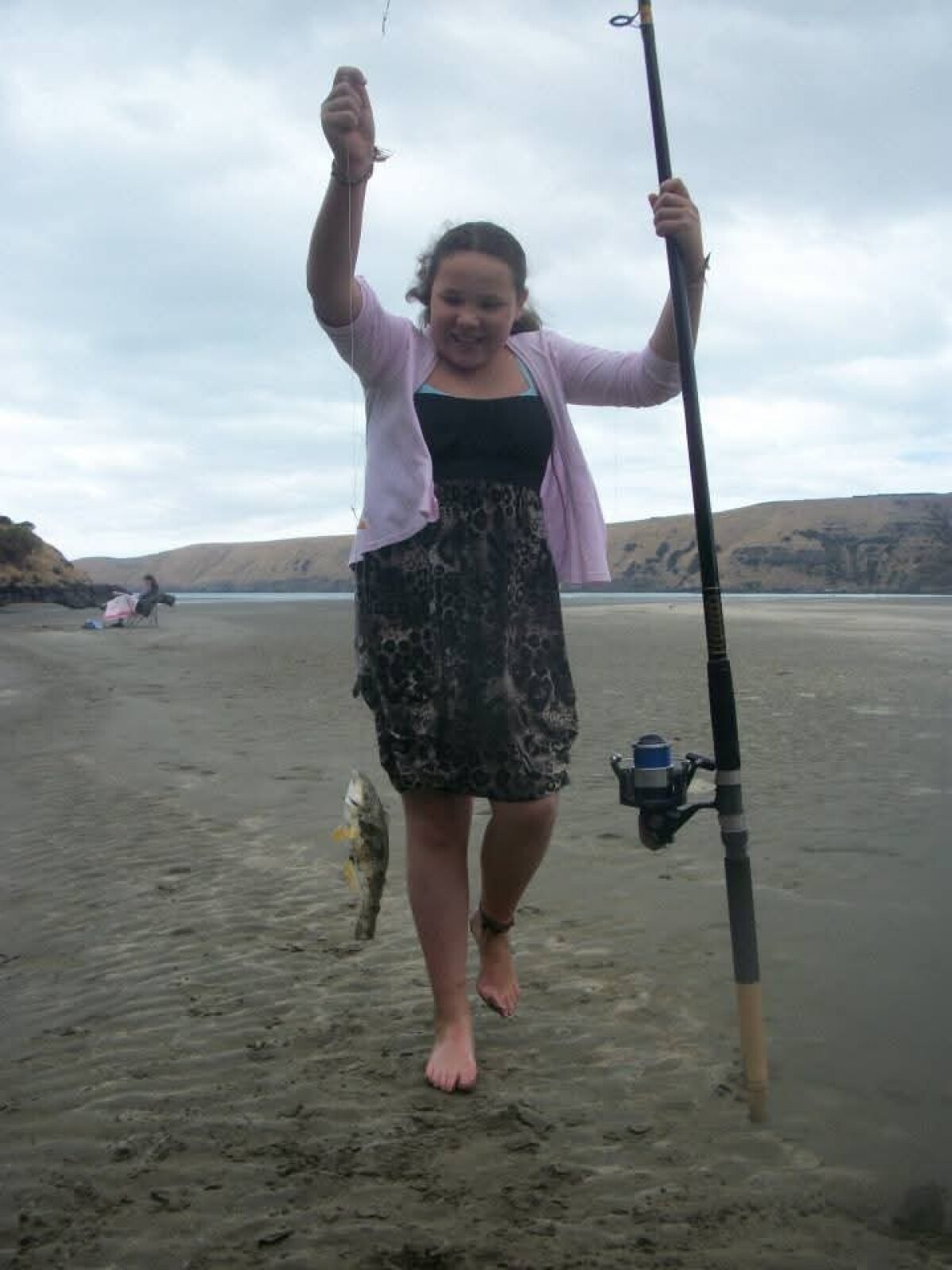 Jade lands a fish at Okains Bay