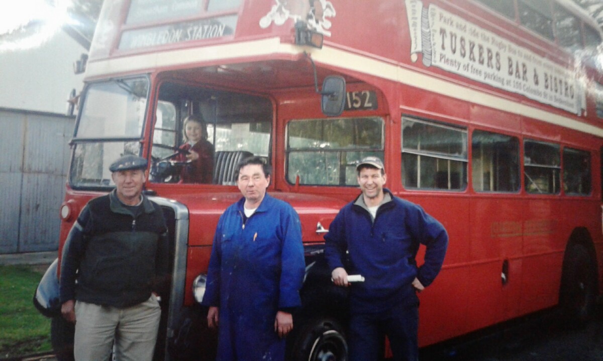 Three generations of Ingram family with double-decker bus