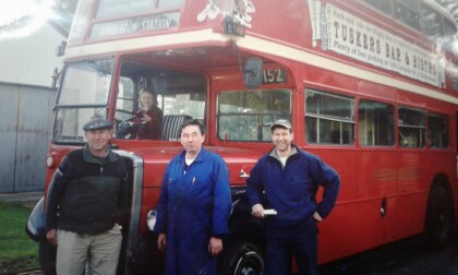 Three generations of Ingram family with double-decker bus